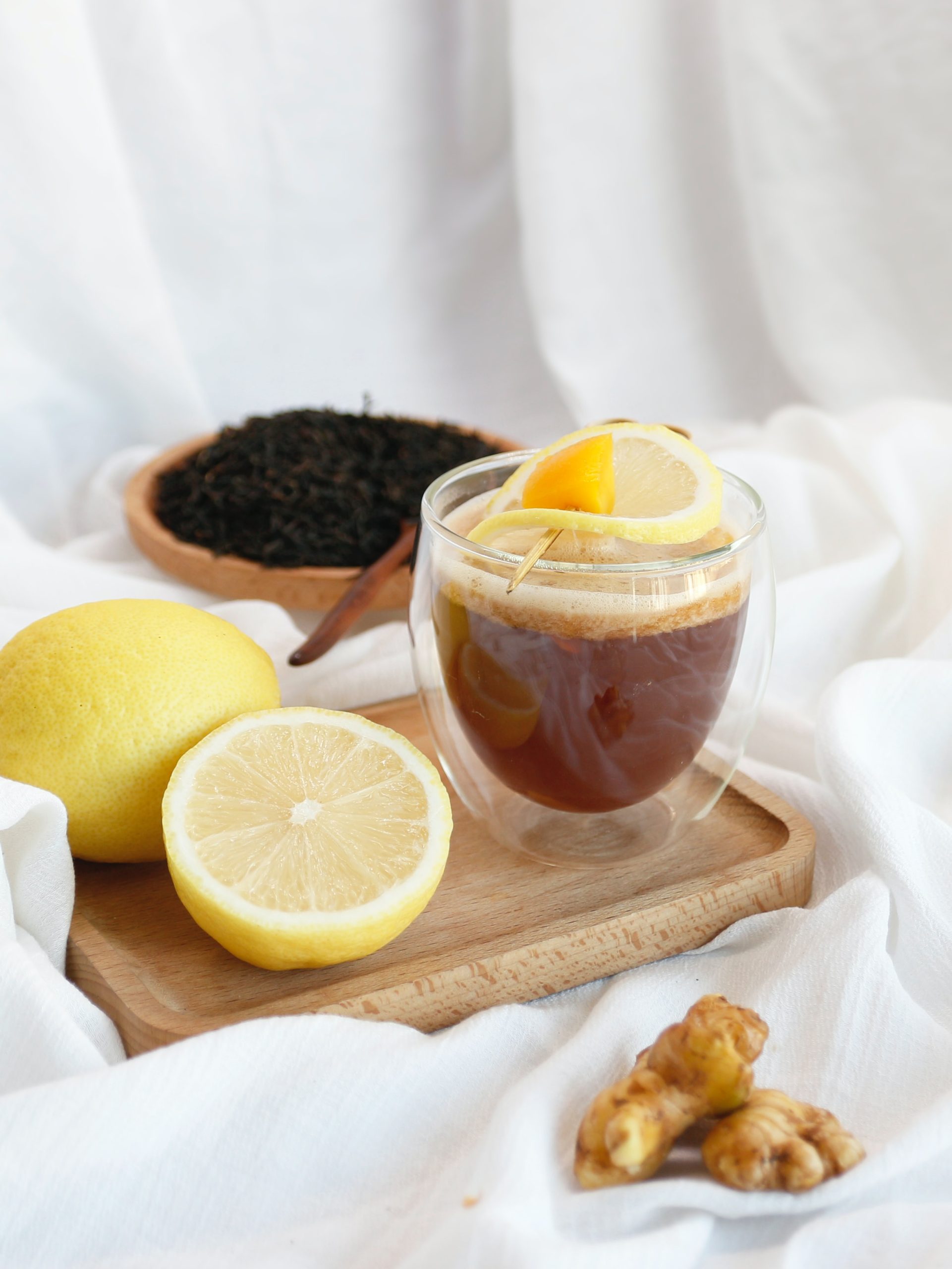 a glass of iced tea with lemons and black tea