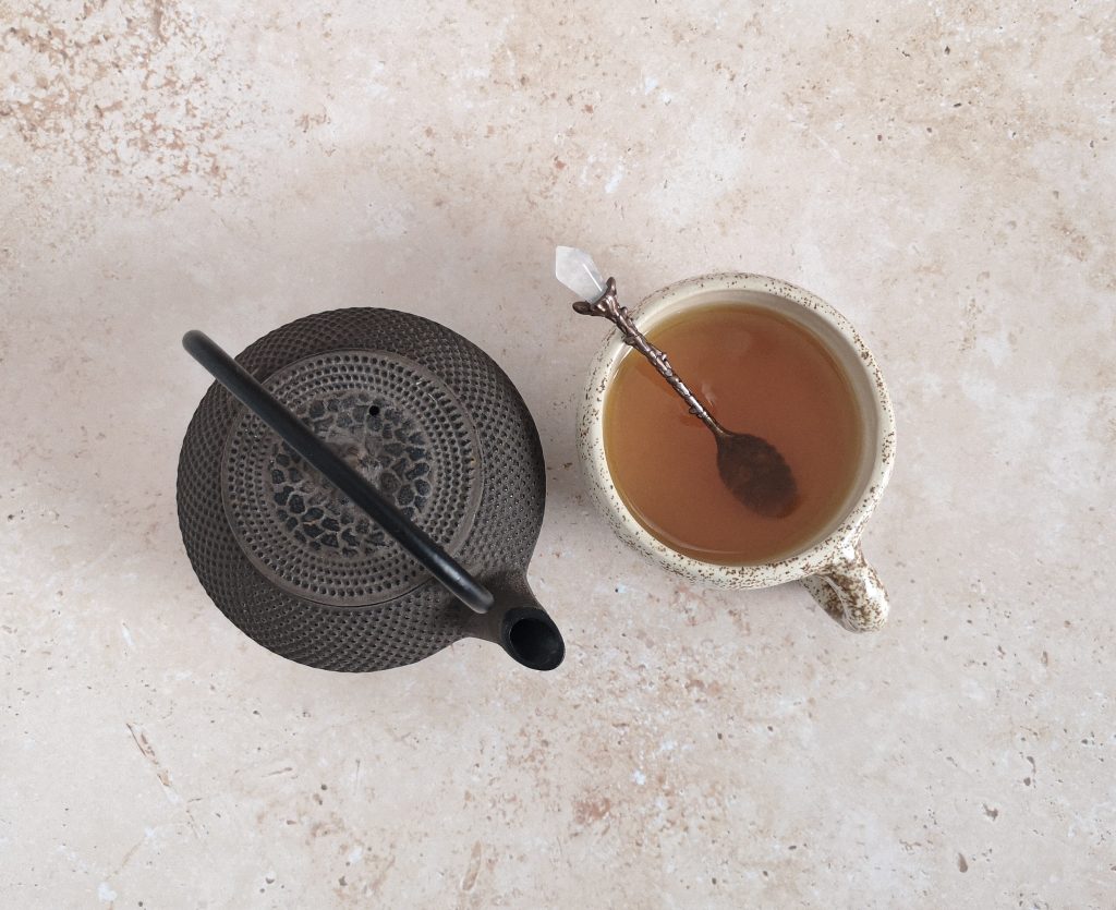 Teapot with a tea mug of turmeric tea.